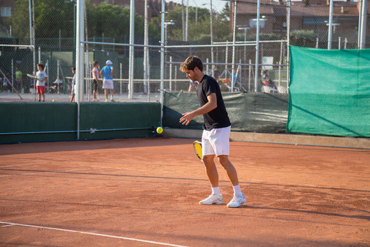 Professional tennis player playing tennis on a clay tennis court on a sunny day. 