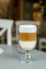 Latte coffee in a glass cup. The concept of hot drinks.