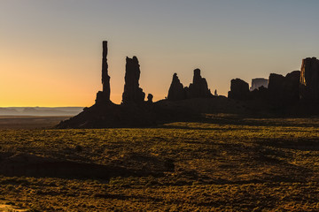 Obraz premium Totem pole and Yei Bi chei rocky spires in early morning in Monument Valley Navajo Tribal Park, Arizona.