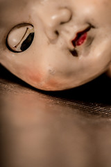Half face portrait of old doll with eyes closed.