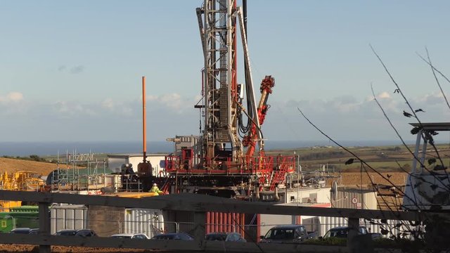Drilling rig working at mining site on a sunny day near Whitby, North Yorkshire, England. North sea seen in the background