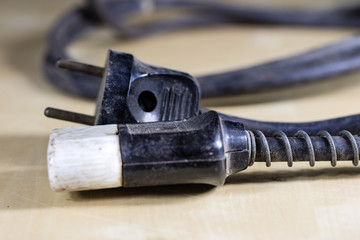 Electric cables, plugs and connectors on a wooden workshop table. Accessories and electrical components.