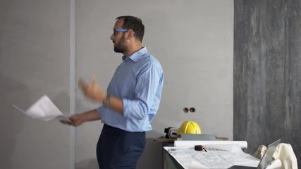 Angry man reading blueprints and leaving new home
