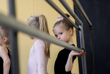 Cute little ballerina looking at the camera. Pretty girl waiting in line for her ballet class.