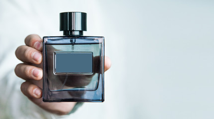 Man holding a bottle of perfume.