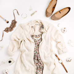 Flat lay fashion concept. Female clothes and accessories: sweater, dress, shoes, watches, perfume, lipstick, bracelet, necklace on white background. Top view.