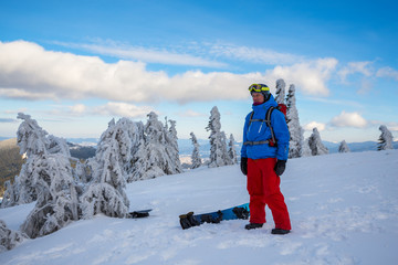 Snowboarder relaxes on a mountain ridge