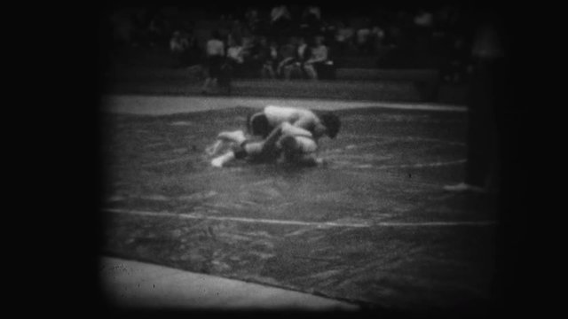 Archival footage of two men wrestling in school