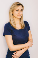 Fototapeta premium Beautiful woman with long straight blond hair on a white background. Studio portrait.