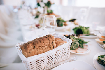 catering table wedding set  with silverware and glass, food and flower decoration