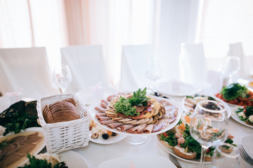 catering table wedding set  with silverware and glass, food and flower decoration