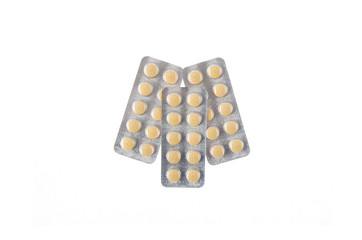 three plates of yellow pills on white isolated background