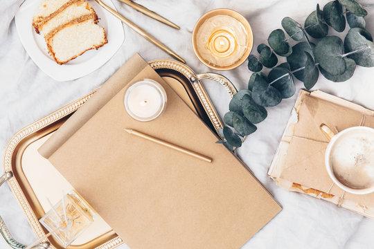 Flat lay composition with craft notepad with copy space. Coffee and breakfast in bed