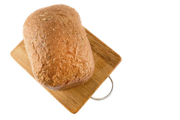 Freshly baked bread on wooden cutting board isolated on white background.