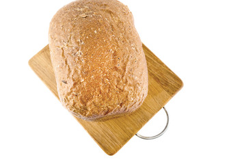 Freshly baked bread on wooden cutting board isolated on white background. Top view.