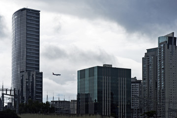 Plane passing between buildings with futuristic lines