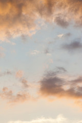 The vertical view of sky background or texture at the sunset time with clouds. Copy space