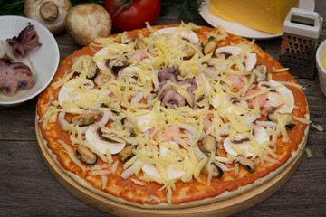 Pizza with seafood on a wooden table.