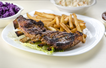 baked ribs and French fries and cabbage salad