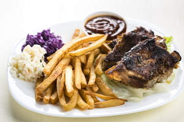 baked ribs and French fries and cabbage salad