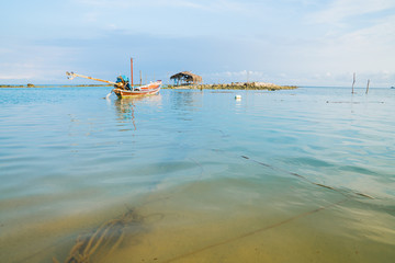 Fototapeta na wymiar Asian idyllic coastal scene with traditional long tail fishing boats.