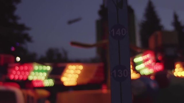 Height meter scale at amusement park attractions with flashing colorful light at dark summer night, slow motion