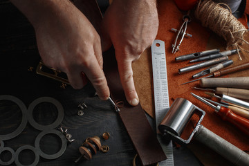 Man working with leather using crafting DIY tools