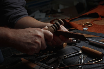 Man working with leather using crafting DIY tools