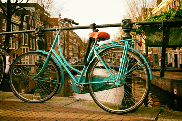 Fototapeta na wymiar Beautiful vingage photo of a Dutch bicycle on a bridge in Amsterdam with buildings in the background and space for text.