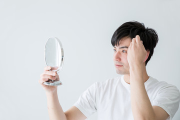 髪の毛を気にする男性
