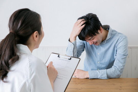 カウンセリングする白衣の女性と男性
