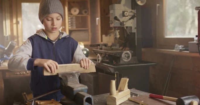 Cute Boy working with Wood at real Workbench