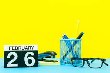 February 26th. Day 26 of february month, calendar on yellow background with office supplies. Winter time