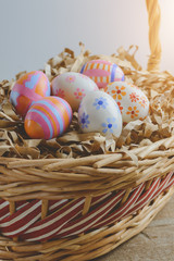colorful handmade easter eggs on Straw paper in basket