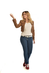 Fototapeta premium full length portrait of blonde girl wearing simple brown jacket and jeans, standing pose on white studio background.