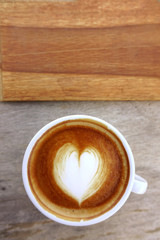 cup of latte art coffee on wooden background
