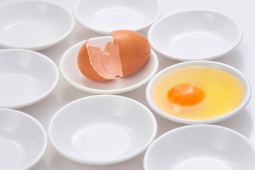 yolks in small bowls  by circle shape repetition in white background.