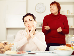 Mature female talking with young sad daughter