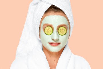 Beauty Treatments. Woman applying facial clay mask at spa