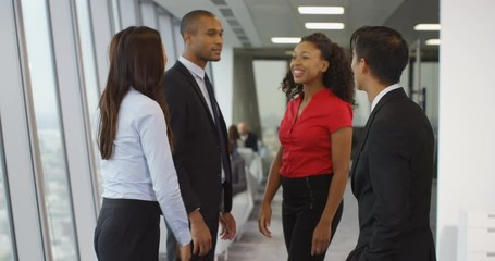 4k, Shot of a diverse group of coworkers shaking hands and talking in an office. Slow motion.