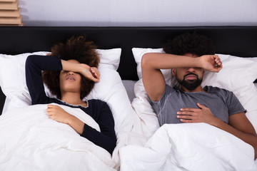 Fototapeta na wymiar Couple Sleeping In Bed