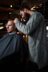 Barber cutting hair of customer