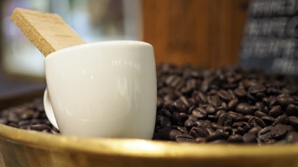 A coffee cup placed on top of coffee beans.