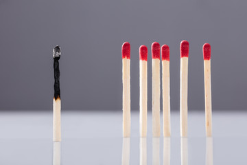 Burnt Matchstick Separated By Red Matchsticks