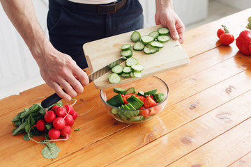 Portrait of handsome smiling man at kitchen. cooking and home concept - close up of male hand...