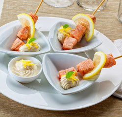 Salmon skewers served with lemon and mayonnaise.