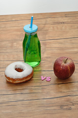 Doughnut and cold drink vs apple. Unhealthy vs healthy
