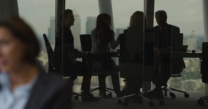 4k, Group of business people having a meeting around a table in an office. Slow motion.