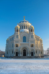 Fototapeta na wymiar Kronstadt Naval Cathedral (Marine Cathedral) near the Saint Petersburg, Russia. Facade with a backlit sun on a blue sky background.