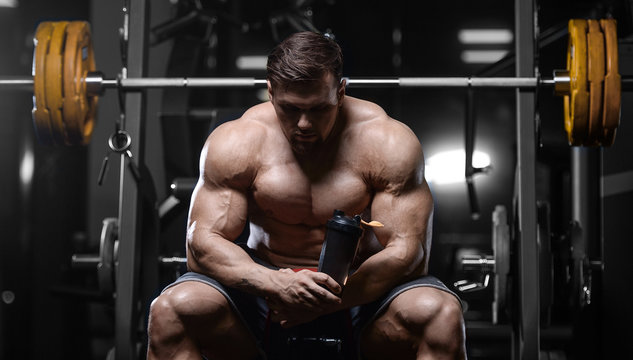 Brutal strong bodybuilder athletic men pumping up muscles with dumbbells.